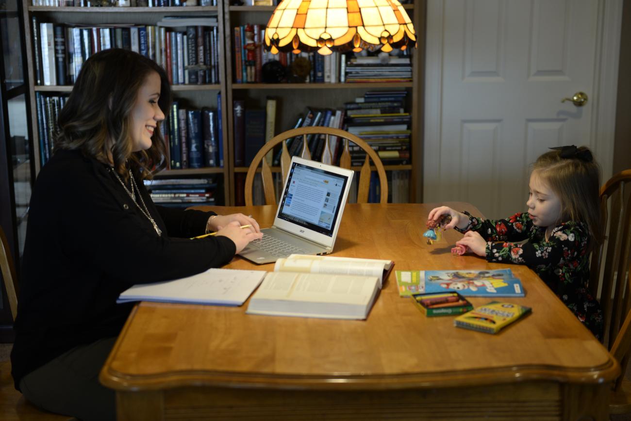 student at computer with child